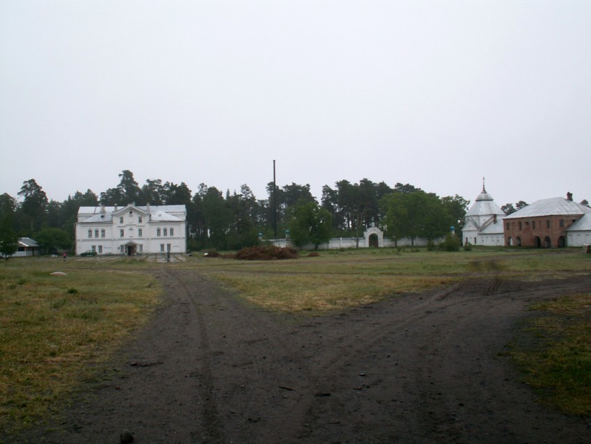 Коневец, остров. Рождества Пресвятой Богородицы Коневский монастырь. общий вид в ландшафте, ограда кладбища и кладбищенский храм Николая Чудотворца