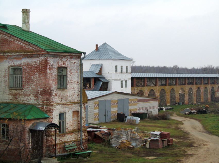 Троицкий Макариев Желтоводский монастырь, Макарьево (Лысковский район, Нижегородская область). дополнительная информация, вид с южной галереи, слева направо Архимандритский корпус, современная хозяйственная постройка, западная надвратная башня, участок западной монастырской стены