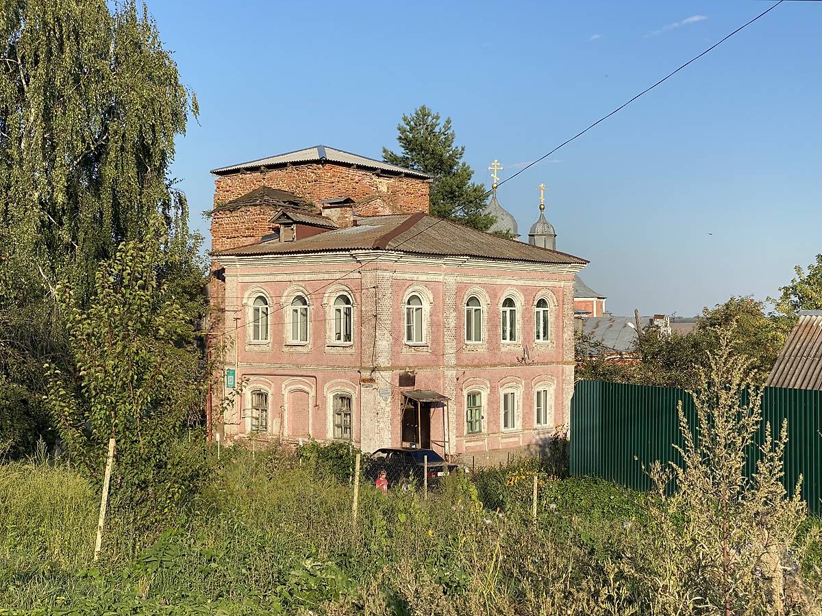 Здание церковно-приходской школы (1898) и краснокирпичный объём бывшей церкви за ней, дополнительная информация. Церковь Алексия, митрополита Московского, быв. Христорождественского монастыря, Болхов (Болховский район, Орловская область)