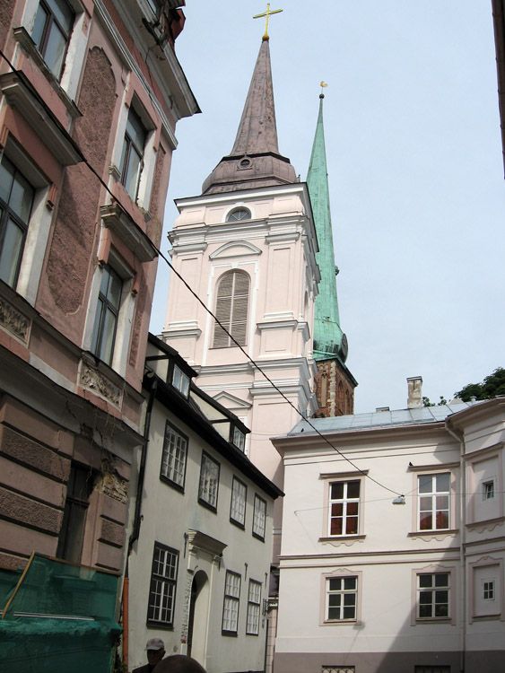 Церковь Алексия, человека Божия, Рига (Рига, город, Латвия). общий вид в ландшафте, Вид на колокольню храма в контексте современной застройки. На заднем плане - шпиль готической церковь св. Екаба.