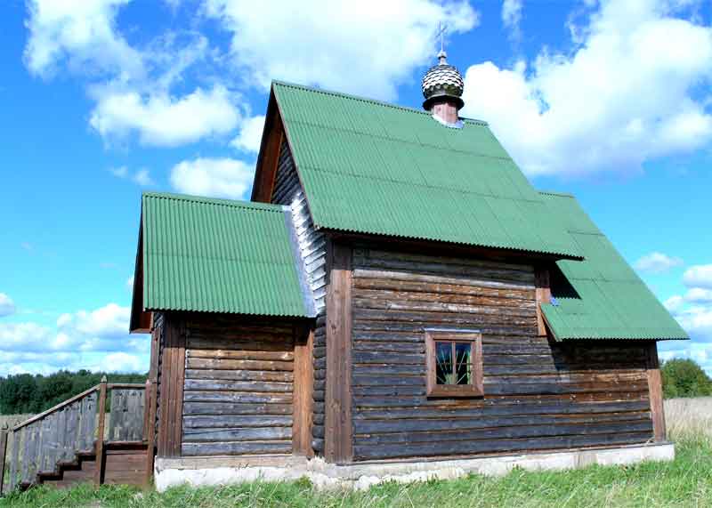 Церковь Казанской иконы Божией Матери (новая), Посадниково (Новоржевский район, Псковская область). фасады, Всвязи с тем, что не было средств для реставрации одноимённого храма постройки 1939г., было принято решение возвести деревянную церковь на окраине села в поле. Между храмами расстояние около одного километра.