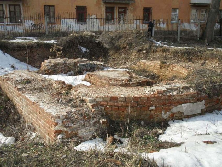 Крестовоздвиженский мужской монастырь. Церковь Воздвижения Креста Господня, Калуга (Калуга, город, Калужская область). дополнительная информация, Фрагмент фундамента апсиды.
На дальнем плане виден жилой дом, построенный на фундаменте средней части храма и колокольни