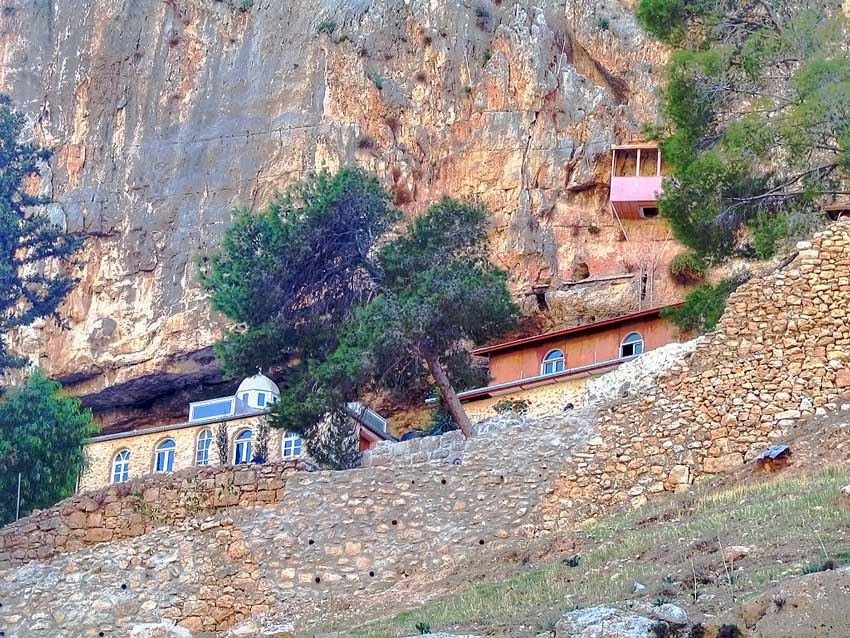 Монастырь Харитона Исповедника, Иудейская пустыня, Вади Кельт (Нахаль Прат) (Палестина, Прочие страны). общий вид в ландшафте, Центральная часть ядра лавры на южном берегу потока. За оградой современного монастыря видны: слевы - церковь Николая Чудотворца, правее -современные кельи и служебный корпус, выше них - благоустроенная древняя пещерная келья. Вид с севера.