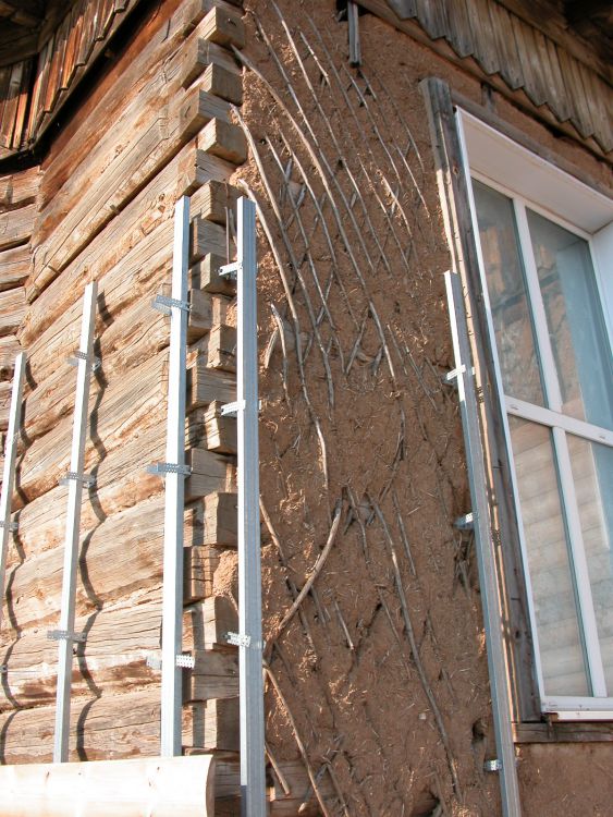 Церковь Покрова Пресвятой Богородицы, Подгородняя Покровка (Оренбургский район, Оренбургская область). архитектурные детали, Угол сруба церкви. Слева - современный блокхаус, Справа видны следы старой обрешетки жердинником и остатки глиняной штукатурки стен (характерный традиционный прием местного в том числе жилого (усадебного) домостроения.