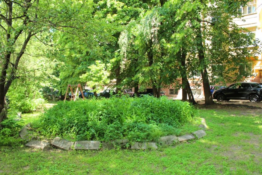 Церковь Михаила Архангела, Калуга (Калуга, город, Калужская область). художественные фотографии, На переднем плане - клумба на месте Архангельского источника, на дальнем плане - жилой дом на месте храма.