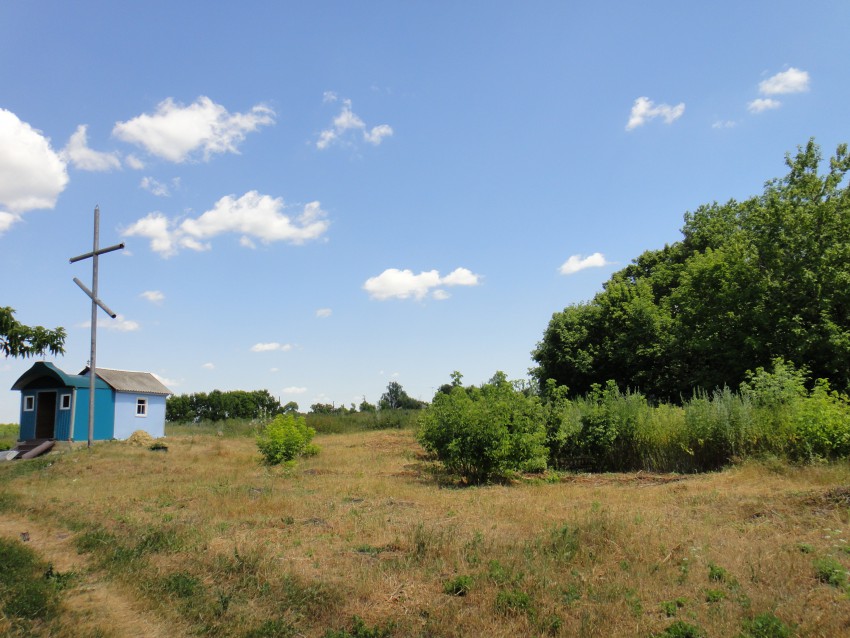 Церковь Покрова Пресвятой Богородицы, Новосильское (Семилукский район, Воронежская область). общий вид в ландшафте, Часовня построенная местными жителями.Остатки храма справа,скрыты деревьями.