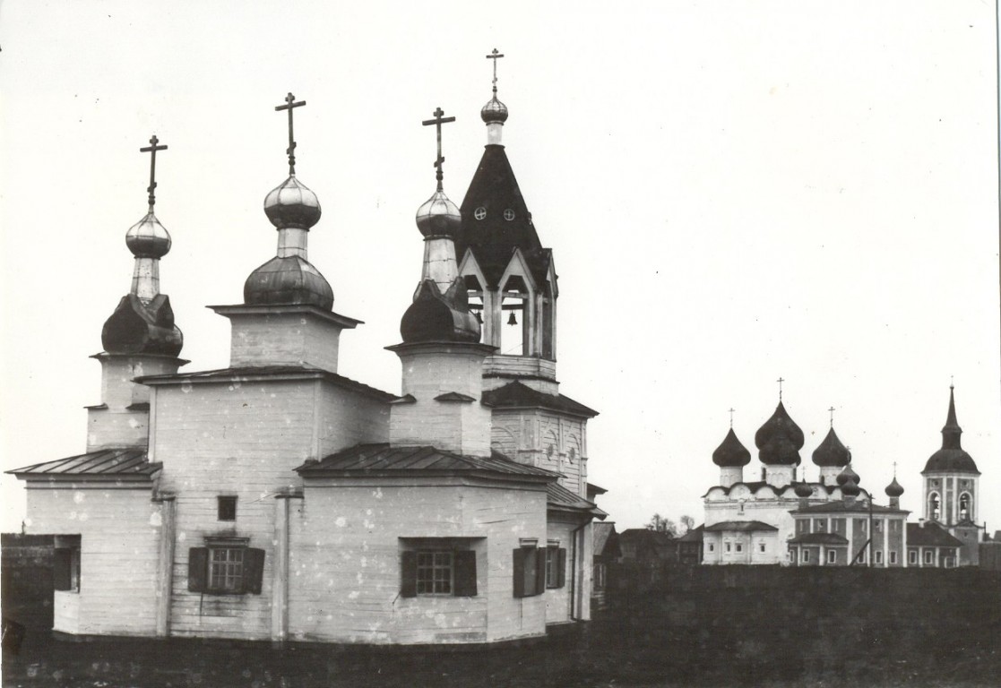 Церковь Спаса Нерукотворного Образа на Валушках, Каргополь (Каргопольский район, Архангельская область). архивная фотография, На первом плане - деревянный храм Спаса Нерукотворного (Спаса на Валушках), т.е. на городских валах, 17 век. Вдали, справа от Воскресенской церкви, каменная церковь Спаса Всемилостивого со своей колокольней.