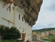 Успенский мужской монастырь. Церковь Марка Евангелиста (пещерная), Вид скалы с церковью от колокольни. Высеченный на скале крест отмечает место алтаря<br>, Бахчисарай, Бахчисарайский район, Республика Крым