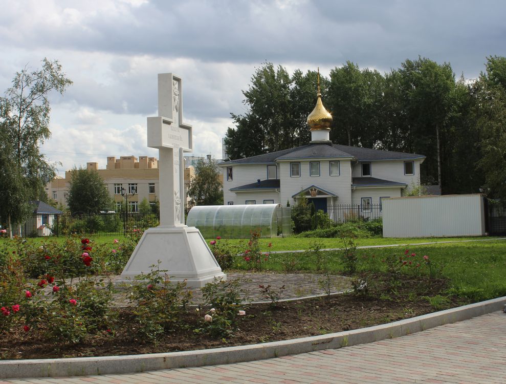 Церковь Воздвижения Креста Господня на Каменке, Приморский район (Санкт-Петербург, г. Санкт-Петербург). дополнительная информация, Поклонный крест в честь новомучеников и исповедников Санкт-Петербургской епархии. На заднем плане - церковь 