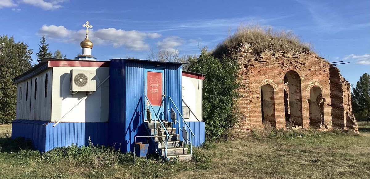 Вид с северо-запада. Слева — временный передвижной храм, общий вид в ландшафте. Церковь Космы и Дамиана, Круглое (Ливенский район и г. Ливны, Орловская область)