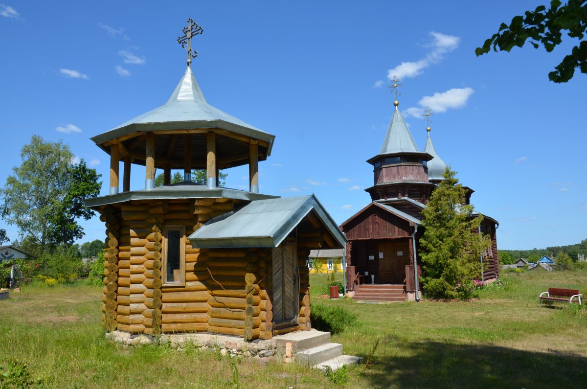 Часовня Покрова Пресвятой Богородицы, Усть-Долыссы (Невельский район, Псковская область). дополнительная информация, а заднем плане - церковь во имя Св. Князя Владимира