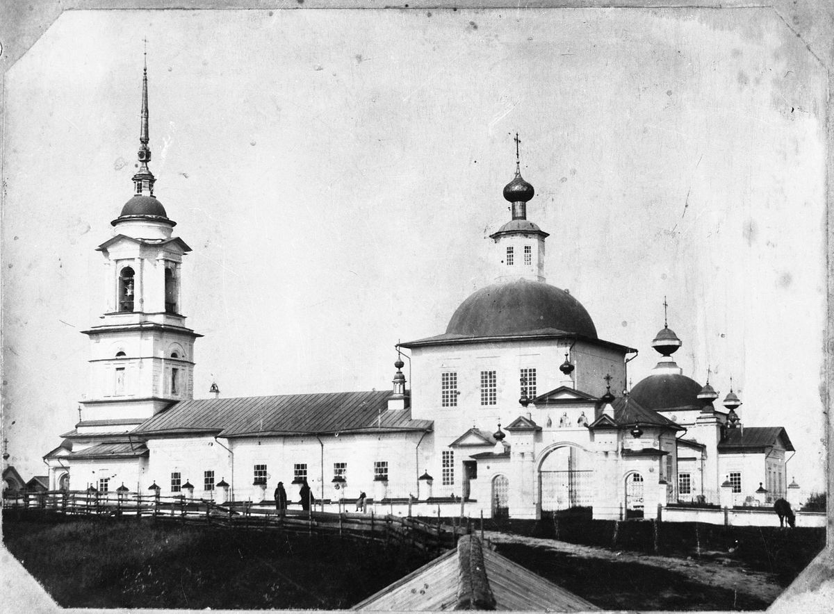 На заднем плане церковь Николая Чудотворца Ембского-Николаевского Погоста, архивная фотография. Церковь Николая Чудотворца Ембского-Николаевского Погоста, Поповка (Вожегодский район, Вологодская область)