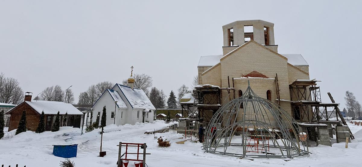 Слева — действующий храм, справа — строящийся. Вид с востока, общий вид в ландшафте. Церковь Казанской иконы Божией Матери, Любань (Любанский район, Беларусь, Минская область)
