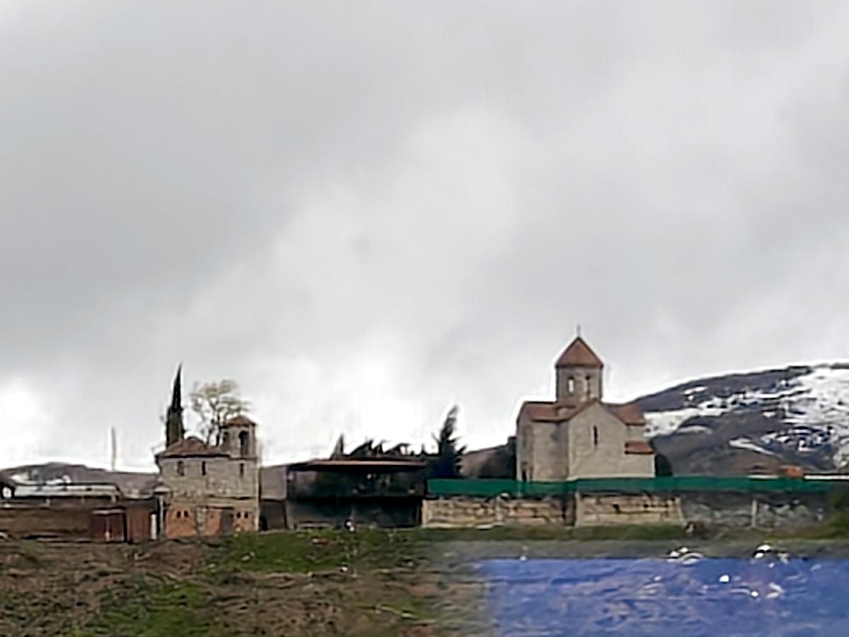 Снято из окна поезда, общий вид в ландшафте. Церковь Георгия Победоносца, Каспи (Шида-Картли, Грузия)